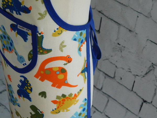 Dino Kinderschürze in blau - orange - braun - creme  und verstellbar in der Halsweite